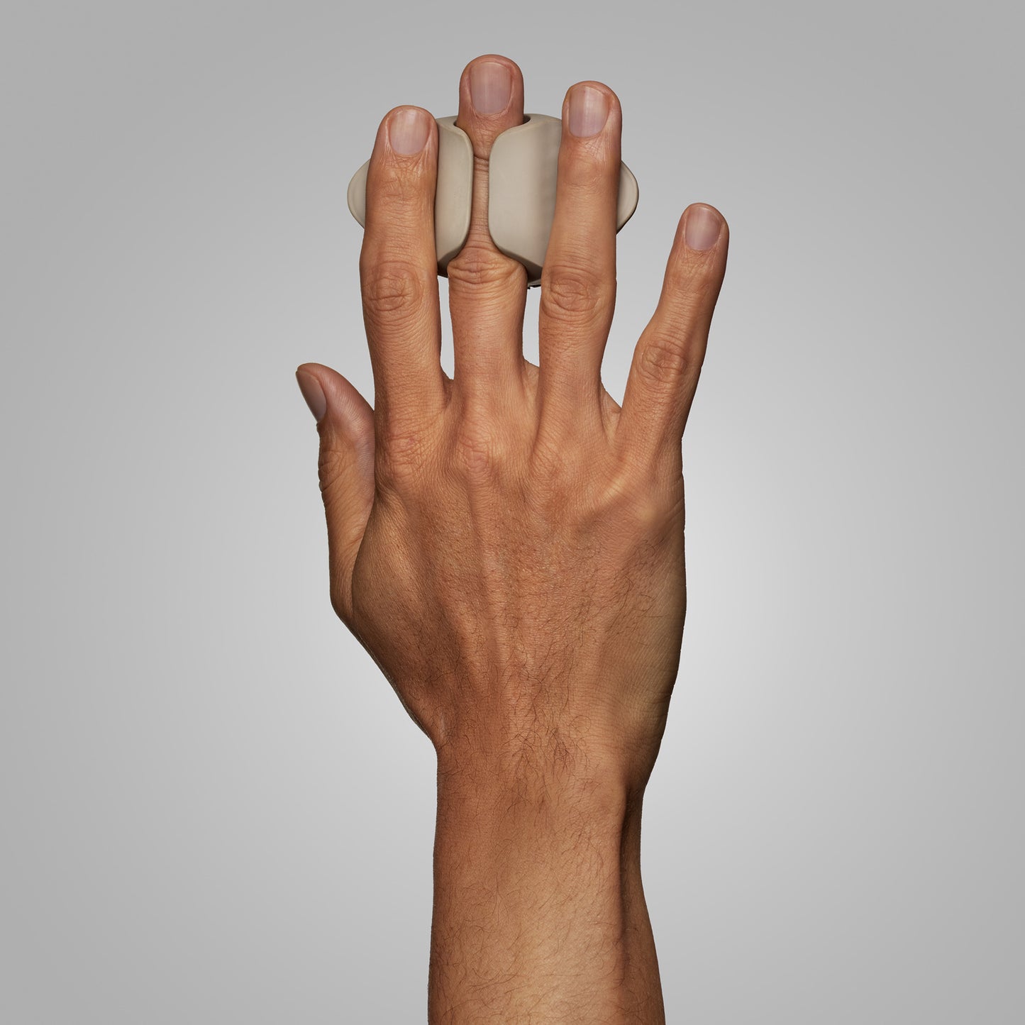 Hand holding CAVEX head shaver on a plain background