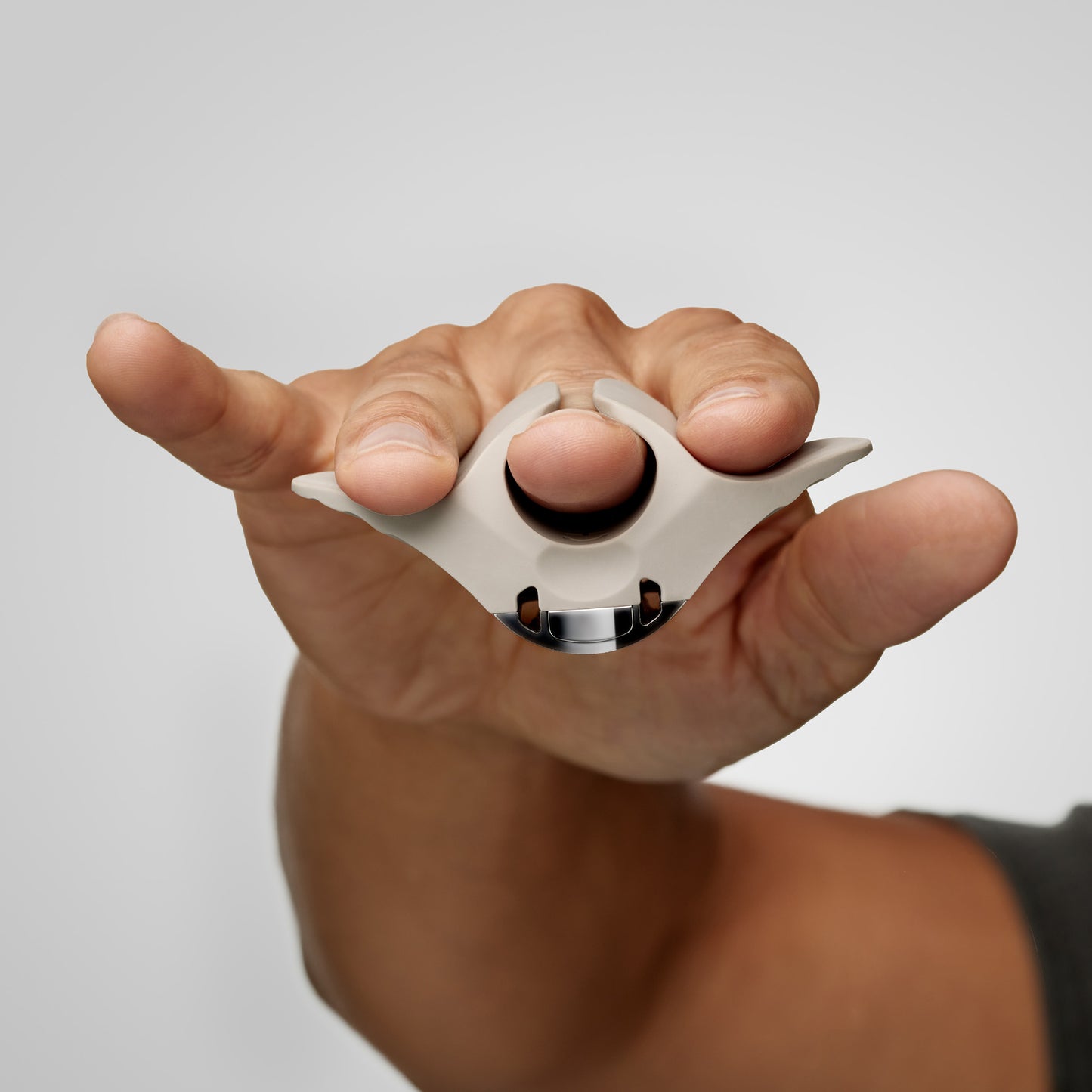 Hand holding a CAVEX head shaver against a light gray background